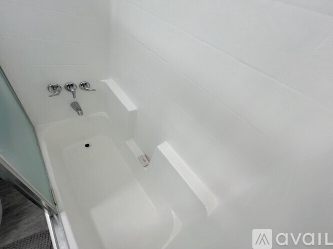 A white bathtub with a glass door and a silver faucet.