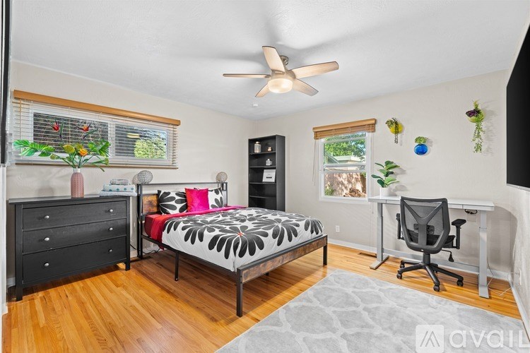 A bedroom with a bed, desk, and chair.