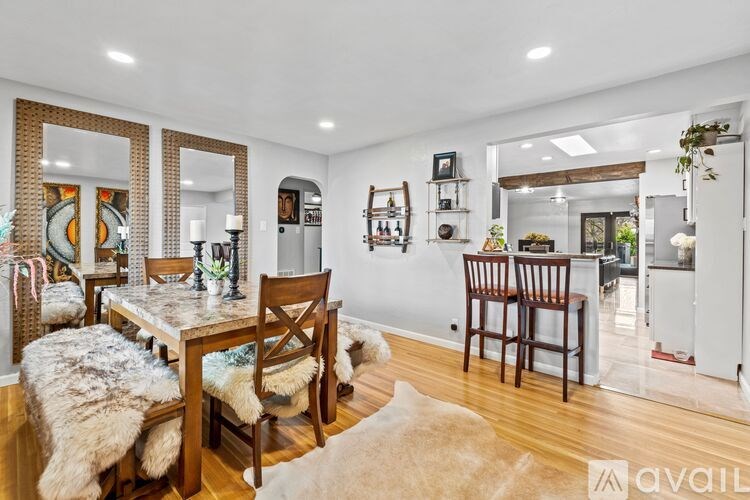 A dining room with a wooden table and chairs.
