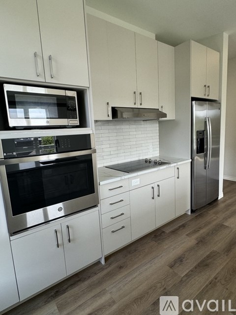 A kitchen with white cabinets and stainless steel appliances.