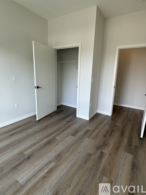 A room with wood flooring and two doors.