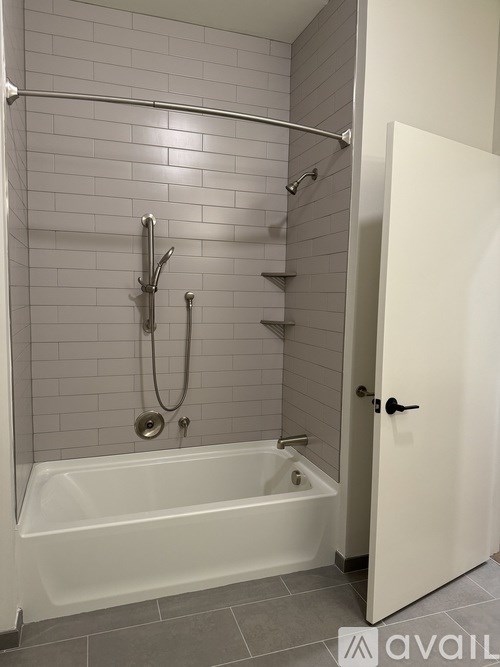 A white bathroom with a tub and a door.
