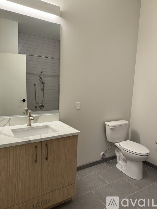 A bathroom with a toilet, sink, and mirror.