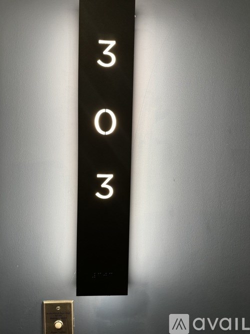 A black sign with the numbers 303 on it.