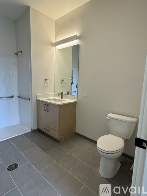A bathroom with a toilet, sink, and mirror.