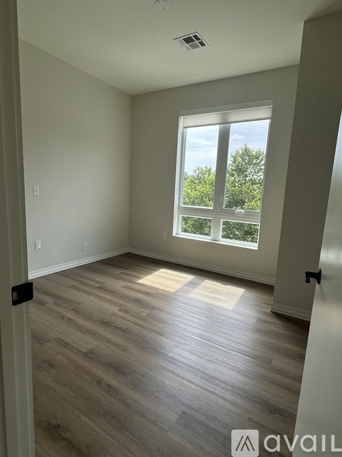 A room with wooden flooring and a large window.