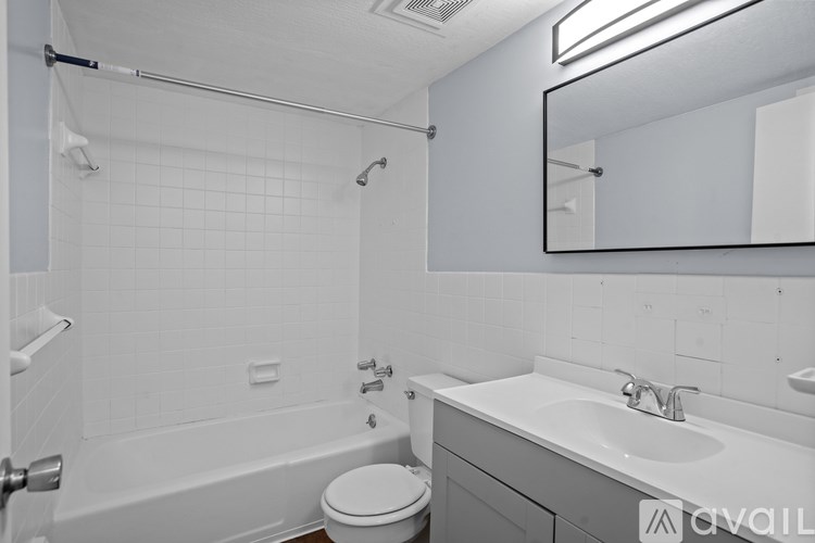 A bathroom with a white tub, sink, and toilet.