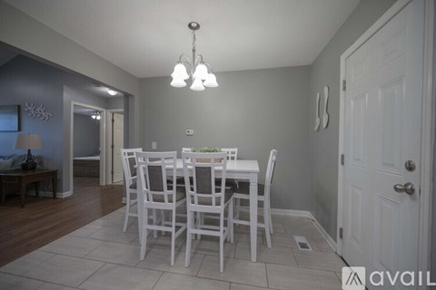 A dining room with a white table and chairs.