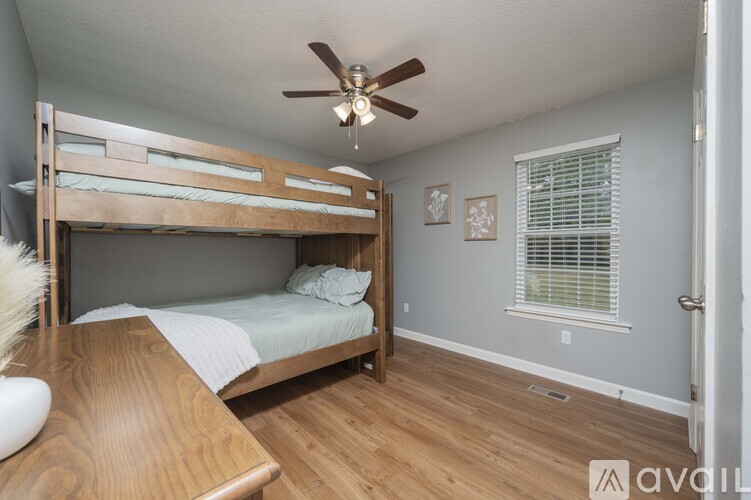 A bedroom with a bunk bed and a ceiling fan.