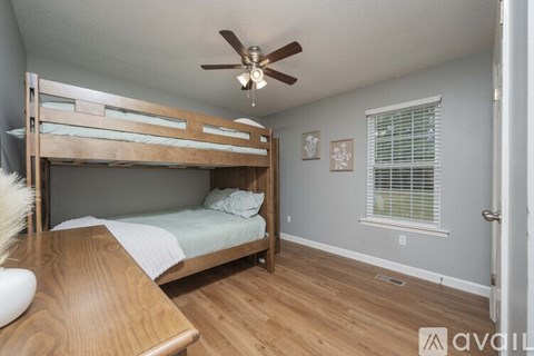 A bedroom with a bunk bed and a ceiling fan.