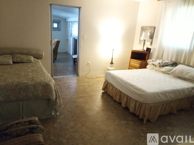 A bedroom with two beds and a lamp.