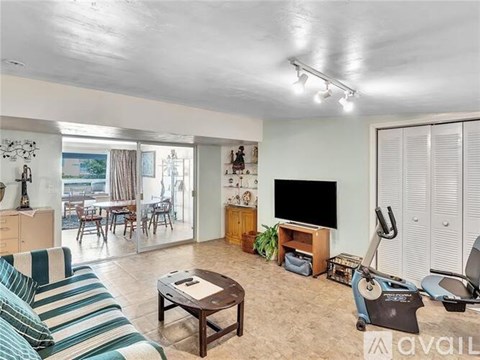A living room with a striped couch and a television.