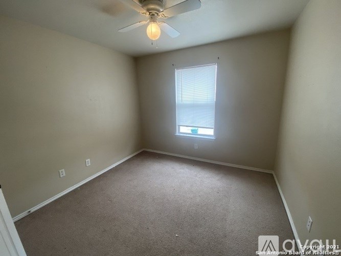 A room with a ceiling fan and a window.
