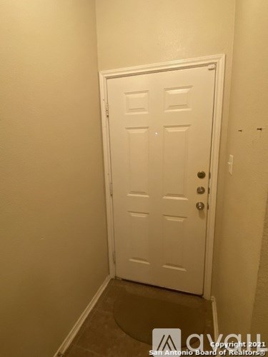 A white door in a room with a brown floor.