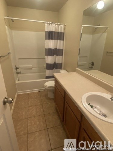 A bathroom with a toilet, sink, and shower.