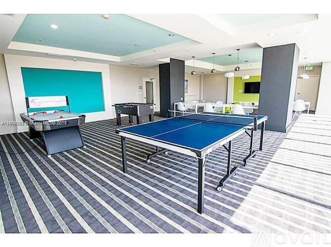 A room with a blue table and striped carpet.