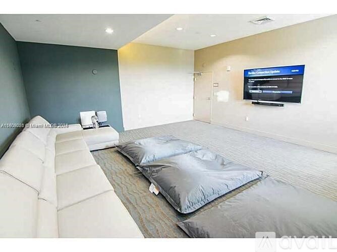 A room with a bed, a couch, and a television mounted on the wall.