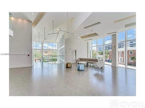 A spacious living room with a large window and a view of the city.