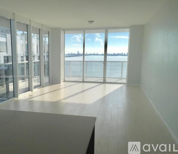 A spacious room with a view of the cityscape across the water.