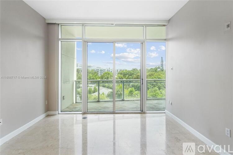 A spacious room with a view of the outdoors through large windows.