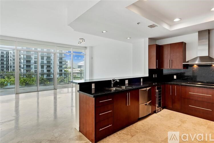 A modern kitchen with dark wood cabinets and a large island.