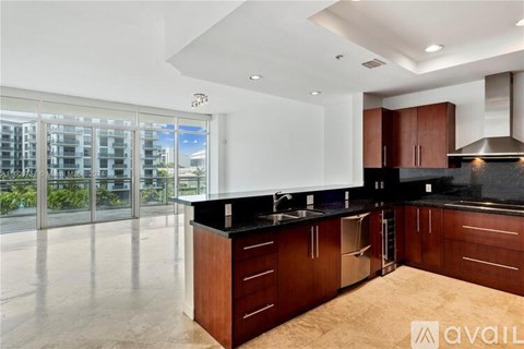 A modern kitchen with dark wood cabinets and a large island.