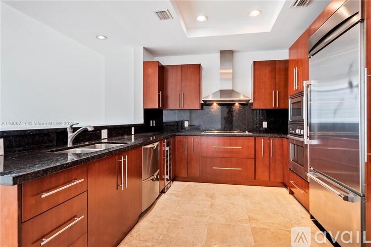 A kitchen with wooden cabinets and black countertops.