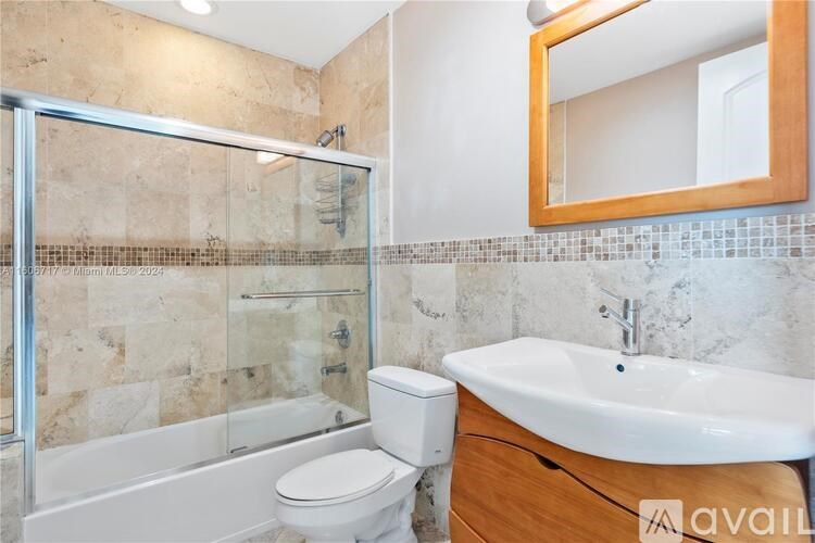 A bathroom with a toilet, sink, and shower.