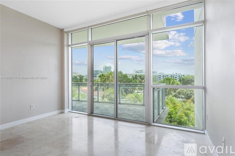 A room with a view of the city through large windows.