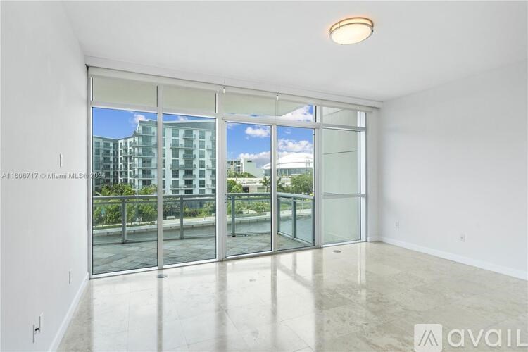 A spacious room with a view of a cityscape through large windows.