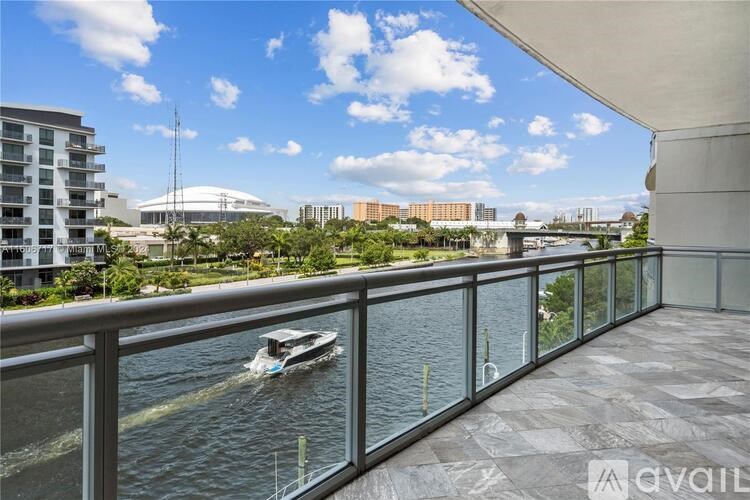A boat is sailing on a river in front of a glass building.