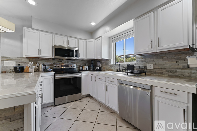 A kitchen with white cabinets and stainless steel appliances.