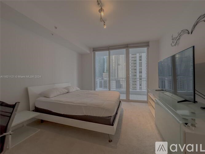 A bedroom with a large bed and a flat screen TV.