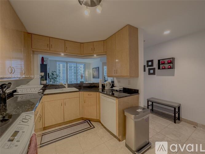 A kitchen with wooden cabinets and a marble countertop.