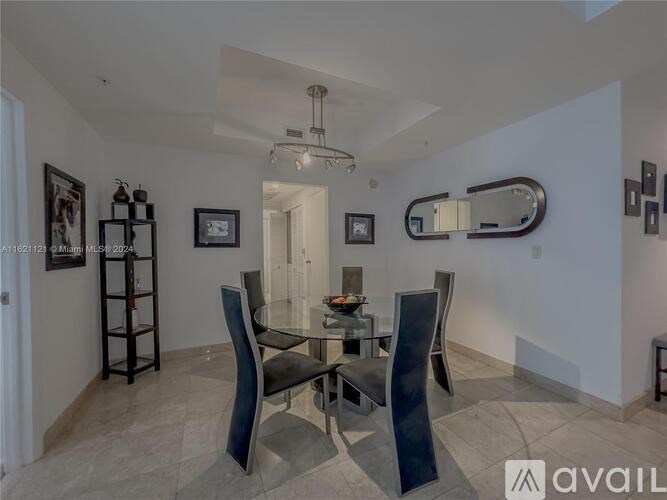 A modern dining room with a glass table and chairs.