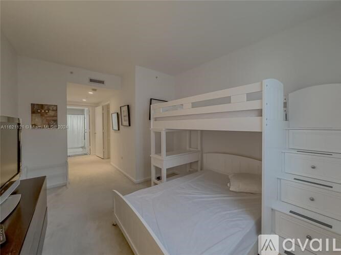 A white bedroom with a bunk bed and a dresser.
