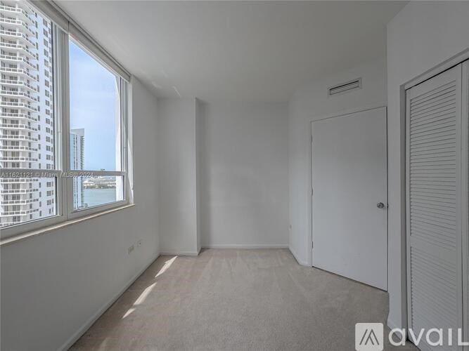 A white room with a large window and a door.