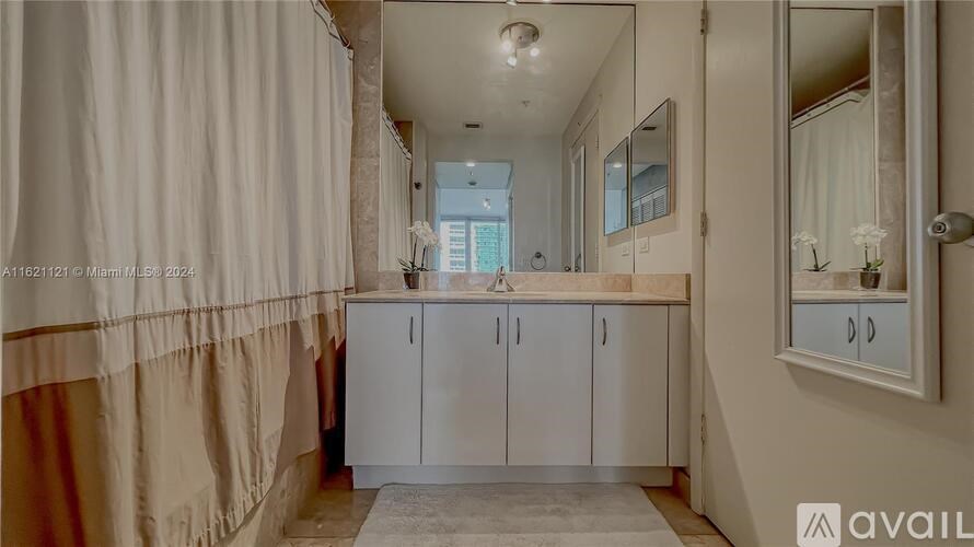 A bathroom with a large mirror and a cabinet.