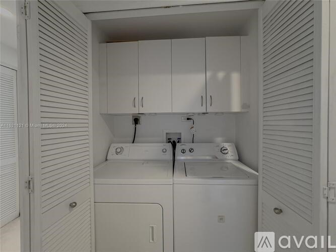 A small white laundry room with a washer and dryer.