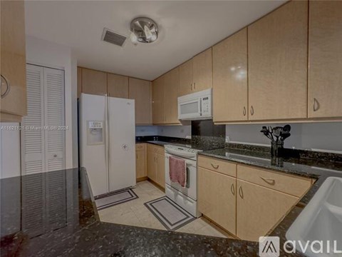 A kitchen with wooden cabinets and a black countertop.