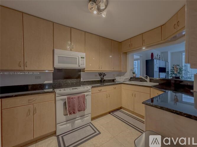 A kitchen with wooden cabinets and a black countertop.