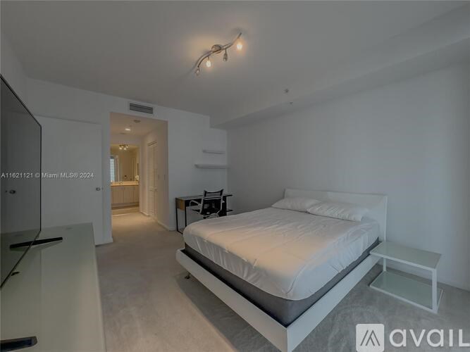 A bedroom with a bed, nightstand, and chair.