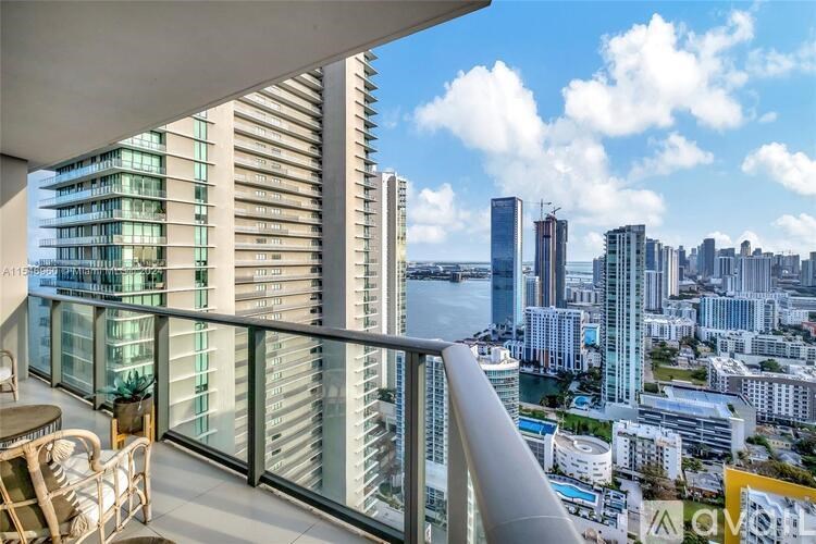 A balcony overlooks a cityscape with a body of water.