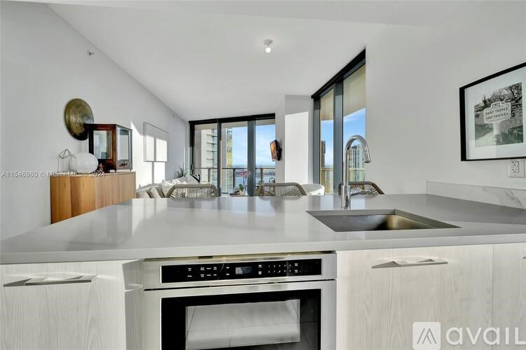 A modern kitchen with a large island and stainless steel appliances.