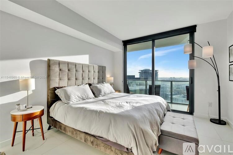 A bedroom with a large bed and a view of the city.