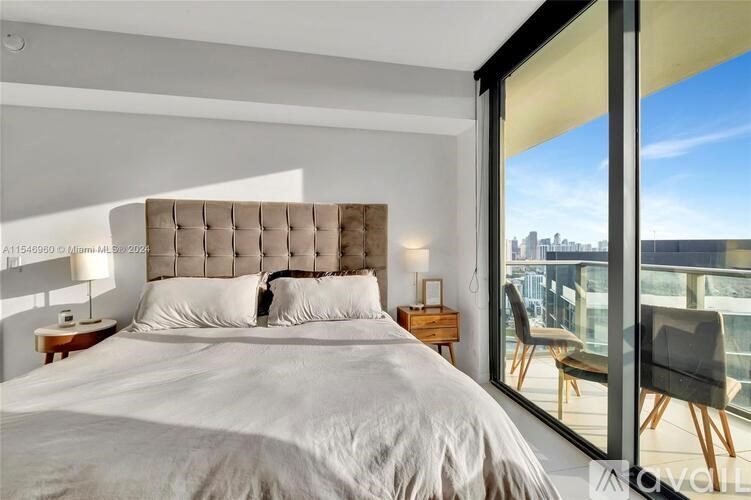A bedroom with a large bed and a view of the city.