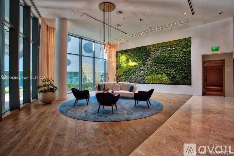 A living room with a green wall and a round rug.