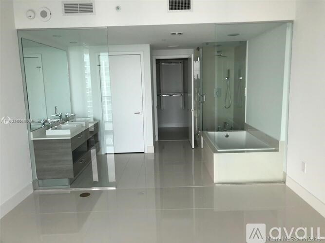 A bathroom with a sink, mirror, bathtub, and shower.