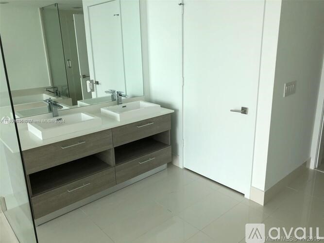 A bathroom with a double sink vanity and a large mirror.