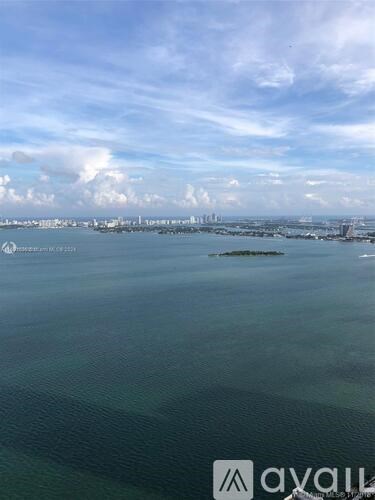 A view of a city skyline from a distance with a body of water in the foreground.